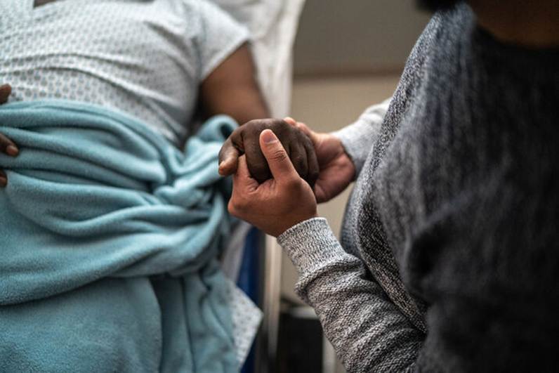 A man holding hand of a patient